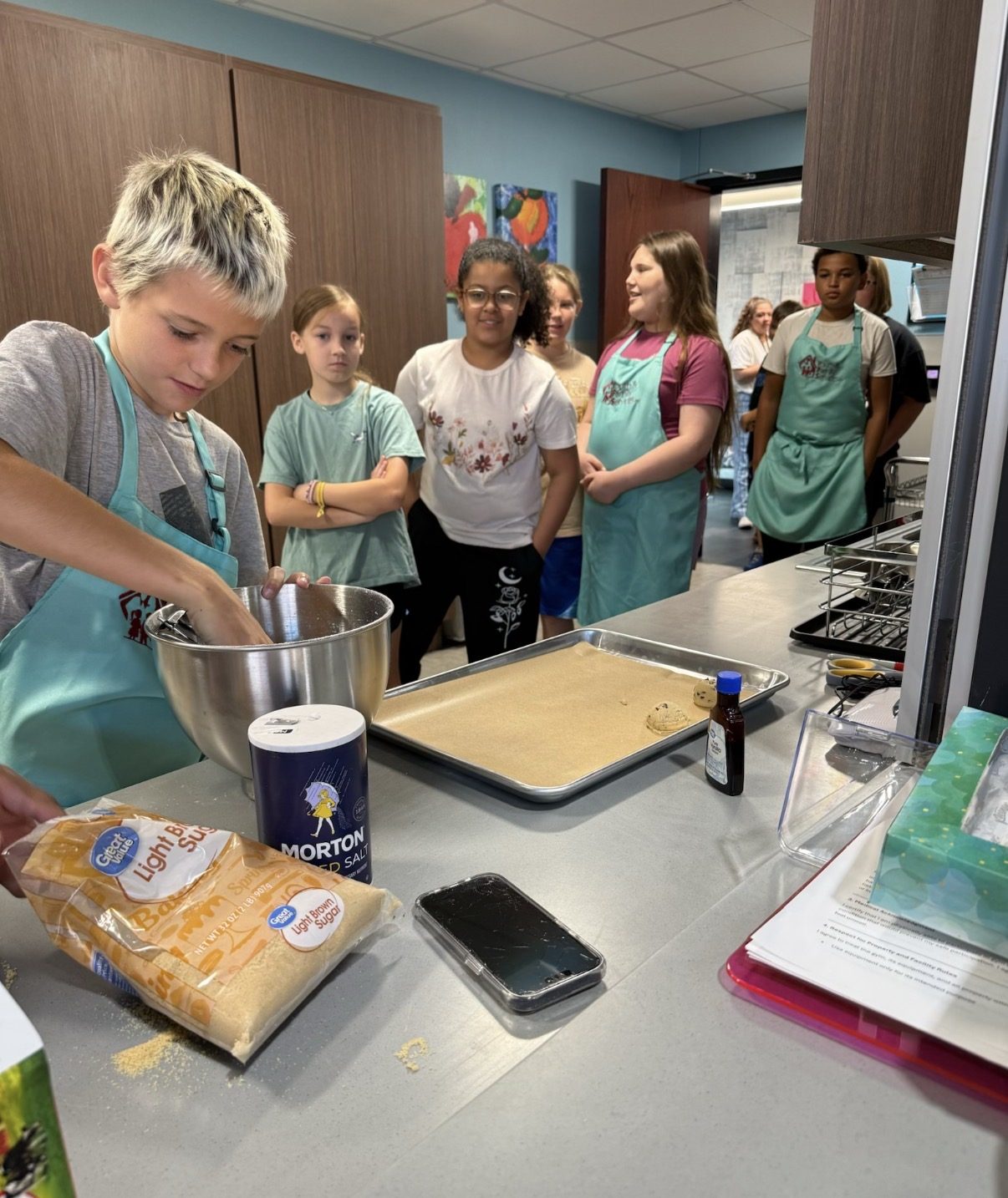 Kids in YFS El Reno aprons learning to bake at a workshop